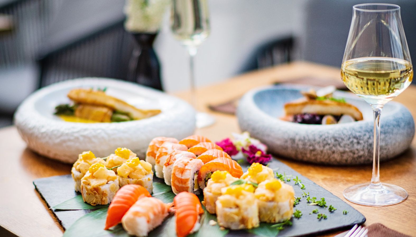 Glasses of white wine on a table with plates of sushi - wine with fish