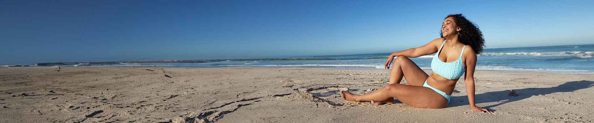Frau genießt die Sonne am Strand
