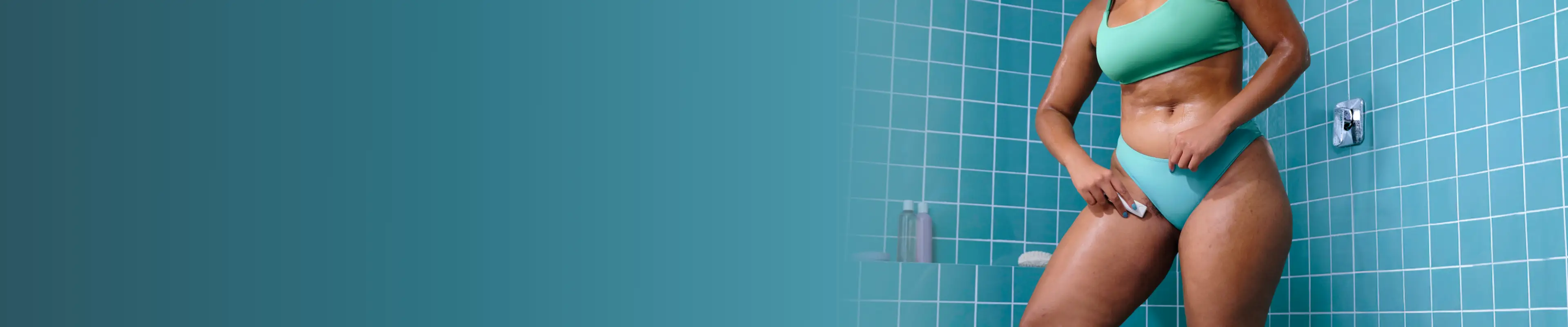 Mädchen sitzt auf einer Badewanne in einem blauen Badezimmer und rasiert sich das Bein