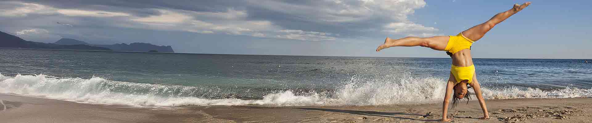 Frau schlägt Rad am Strand