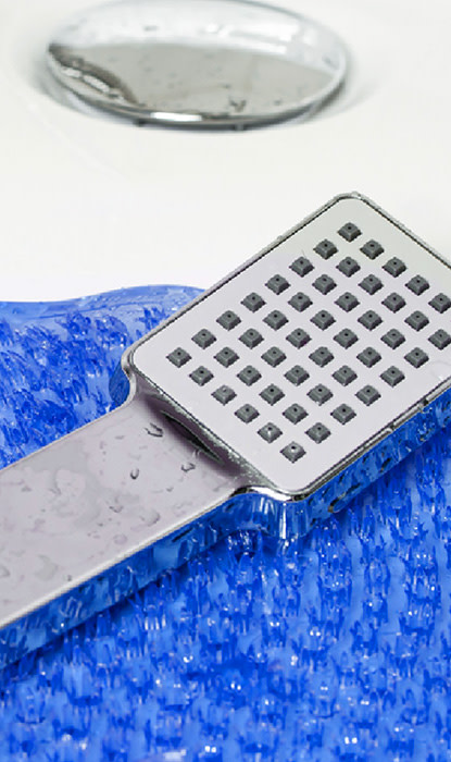 The shower handle is on the wet blue carpet