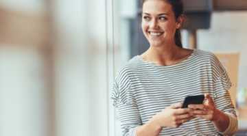 Junge Unternehmerin nutzt Online-Vergleich von Finanzchef24 auf ihrem Smartphone.