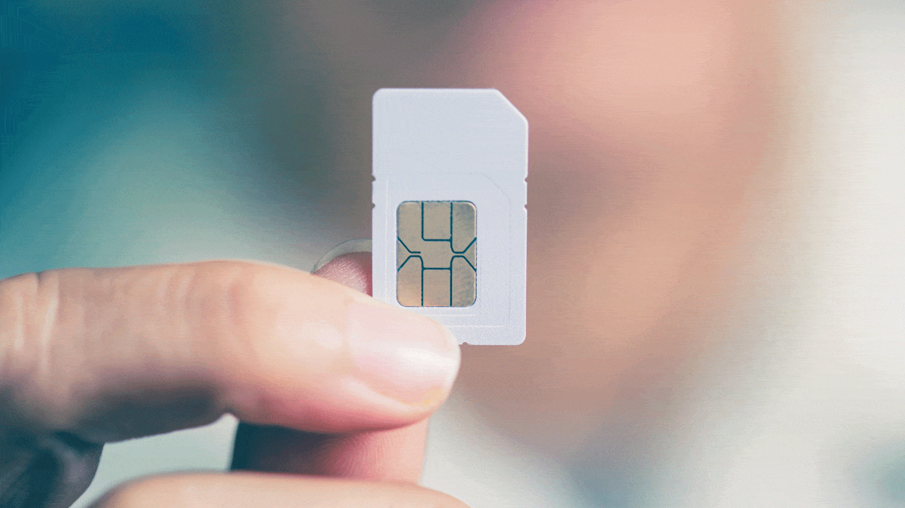 User holding an IoT SIM card, ready to insert in an IoT device.
