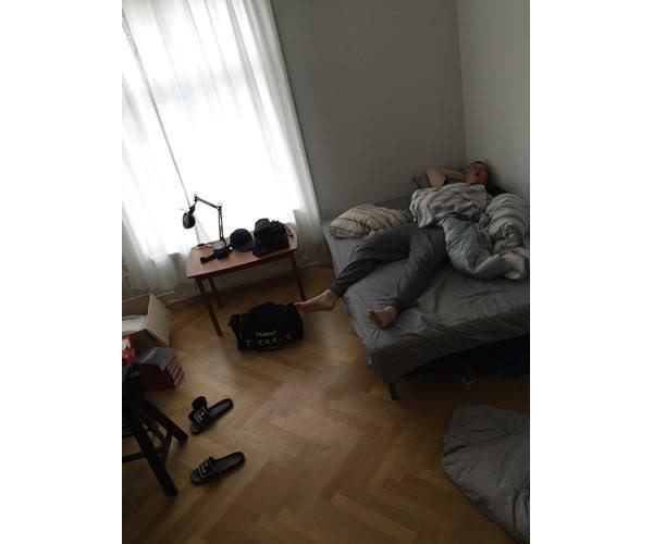 A man sleeping in a messy bedroom