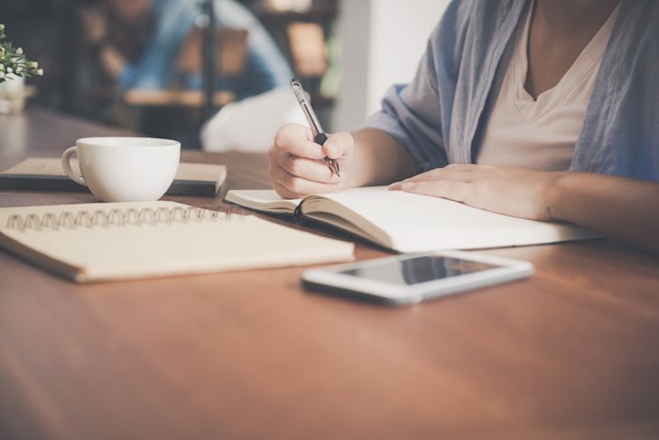 A woman writing something in a notebook