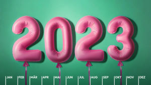 Pinke Luftballons bilden die Jahreszahl 2023 vor einem grünen Hintergrund