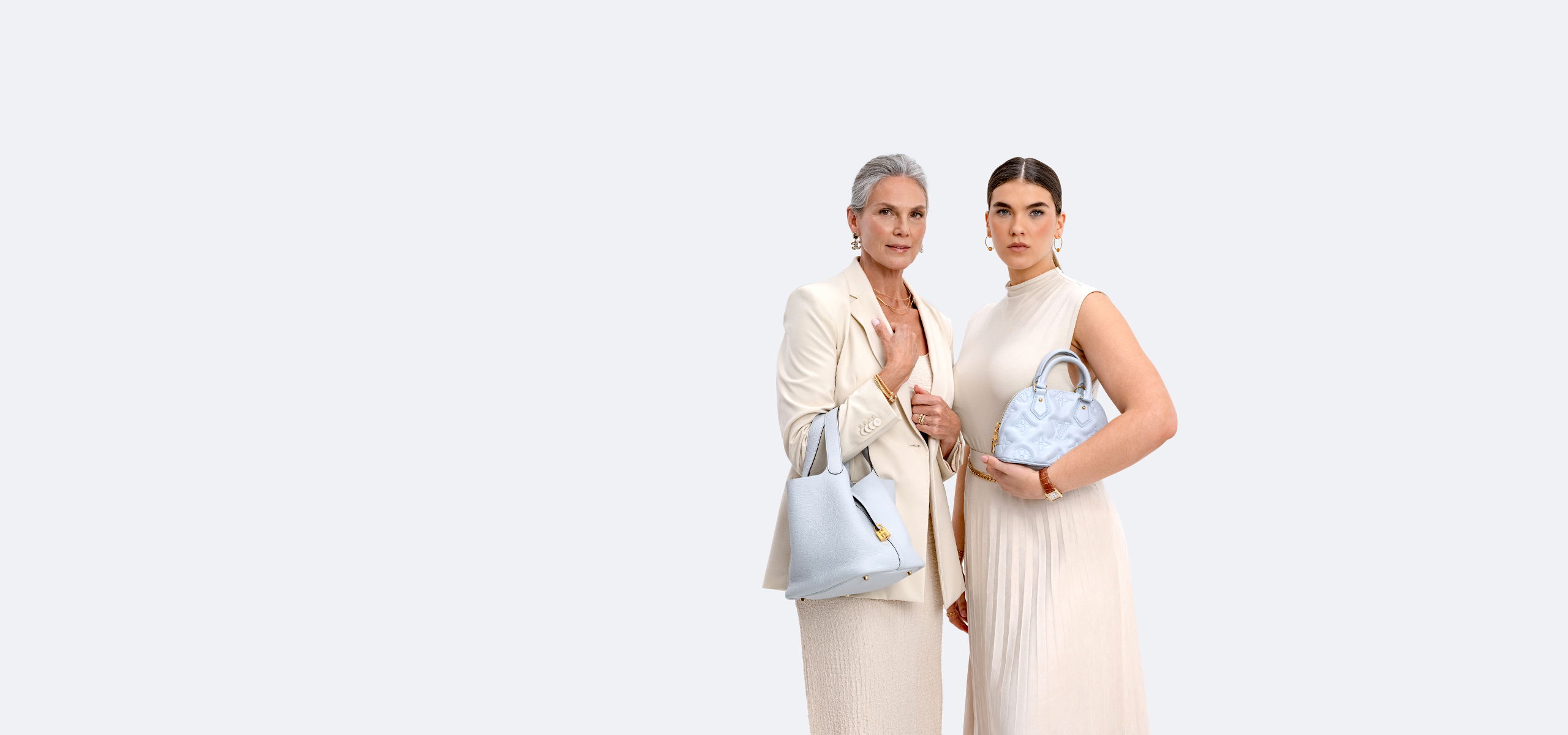 one woman wearing a beige dress and blazer holding a light blue Hermes Picotin bucket bag and another woman wearing a beige sleeveless dress holding a light blue Louis Vuitton monogram embossed mini Alma bag