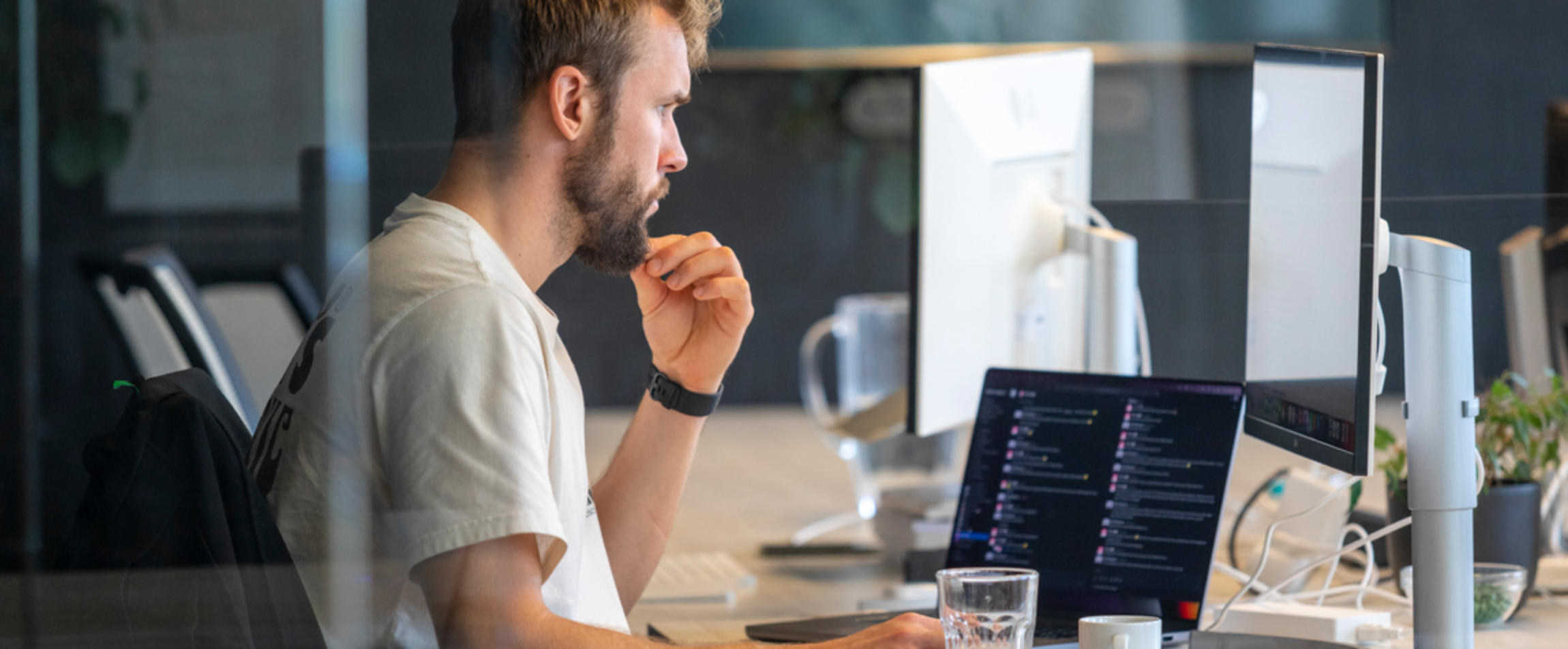 Developer Youri werkt in een meeting ruimte.