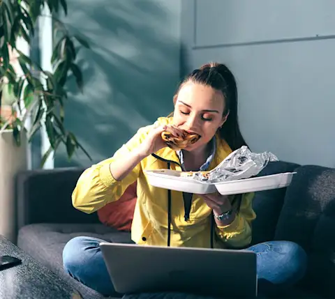 DDfW - Blog - Tips for Ordering Lunches Your Remote Team Will Love - Eating in front of laptop