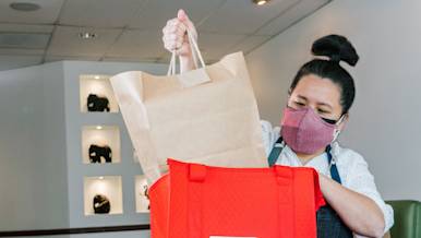 Person putting food in DoorDash bag