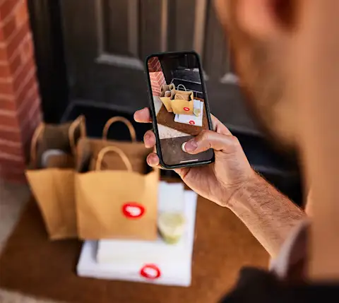 Dx Blog - How Does Pizza Delivery Work on DoorDash? - Dasher taking picture of delivery with phone