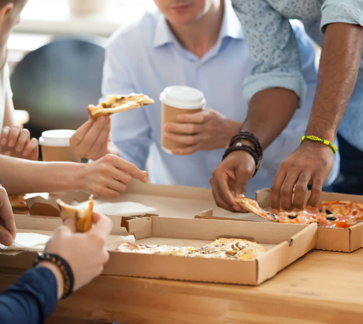 Coworkers indulging on an easy work lunch of pizza