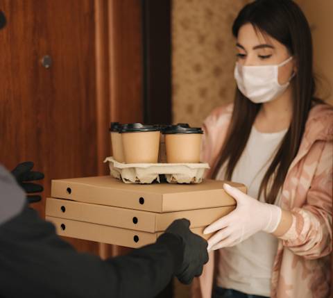 Customer receiving food order with mask
