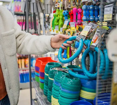 Dx Blog Pet Store Close-up Customer Hand Selecting Dog Toy