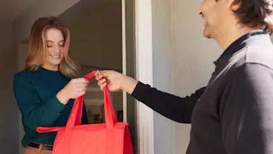 Dasher handing off bag to customer