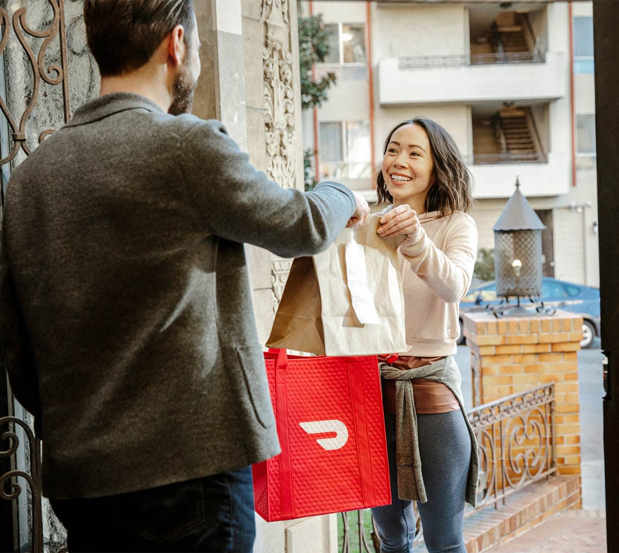 DDfW - Blog - Tips for Ordering Lunches Your Remote Team Will Love - Handing Dasher bag