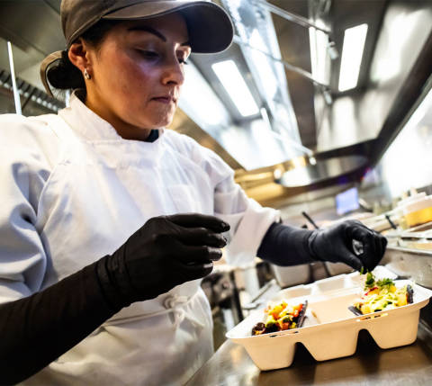 Mx Blog - The 18 Most Popular Types of Restaurants, From Fine Dining to Food Trucks - worker adding food to takeout container