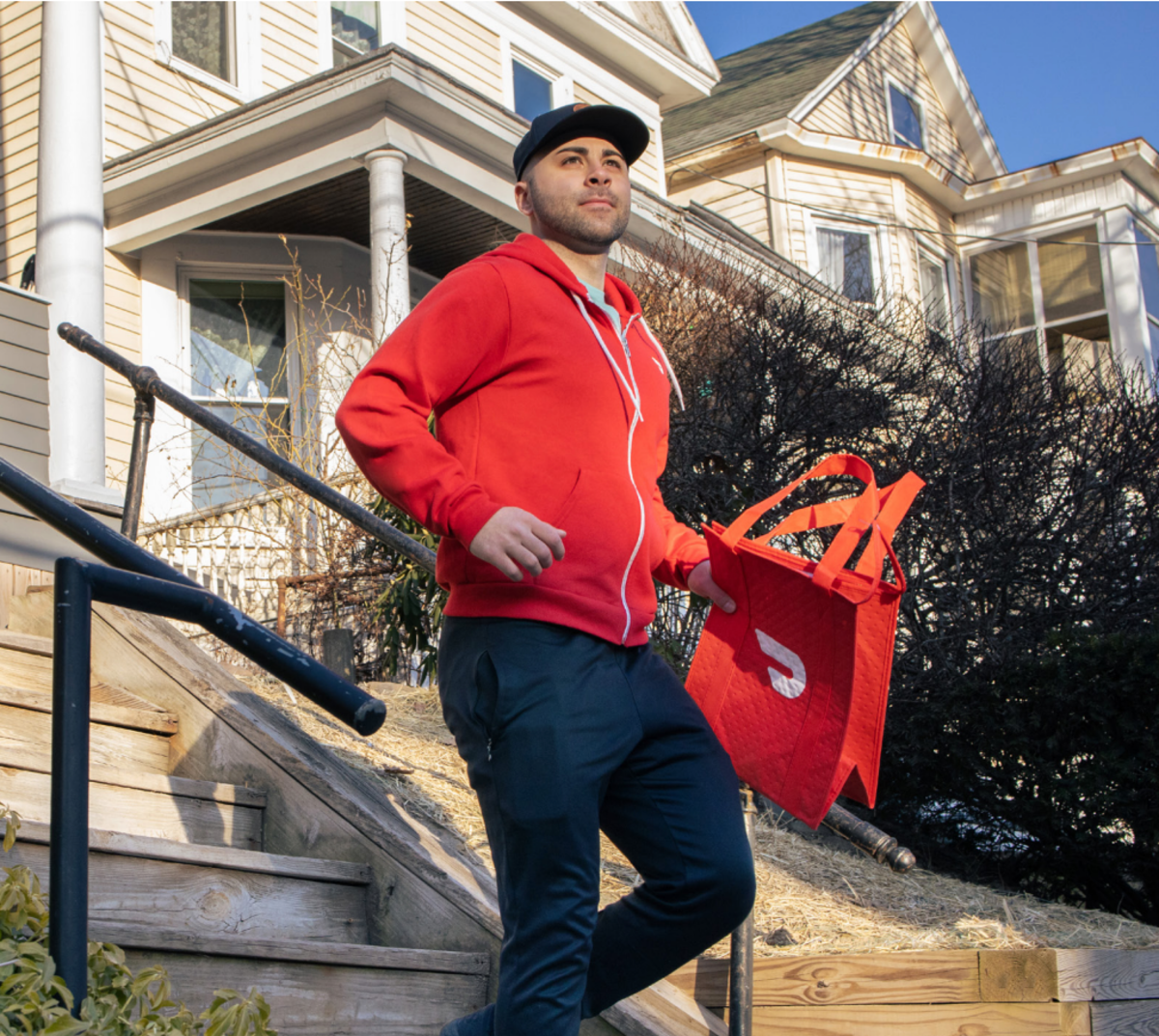 Male Dasher descending stairs in front of a home
