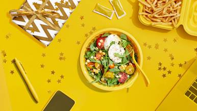 Salad bowl flanked by present, french fries and laptop