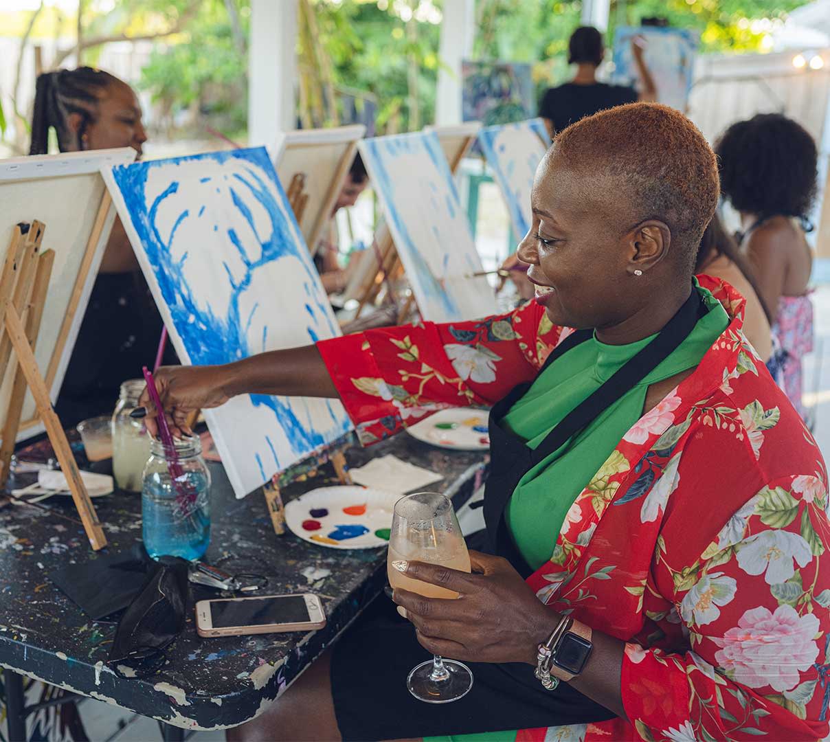 Woman painting with wine glass in hand