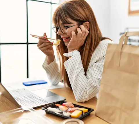 DDfB - Blog - Make New Employees Feel Welcome with a Rewarding Onboarding Experience - employee eating in front of computer during onboarding meeting