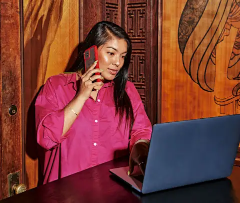 Person on phone with laptop