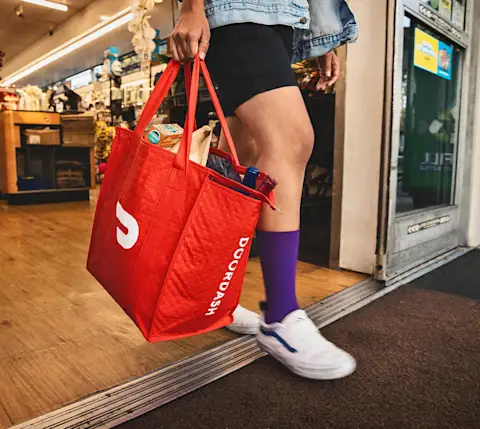 Dx Blog - How to Deliver Alcohol with DoorDash as a Dasher - purple socks Dasher with bag
