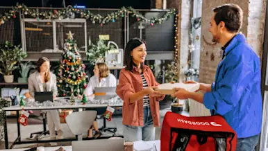 Dasher delivering a meal to a Christmas decorated office