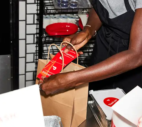 Mx Blog (US/CA/AU/NZ) - Food Delivery Packaging and Container Tips for Restaurants - applying DD sticker/tag on bag