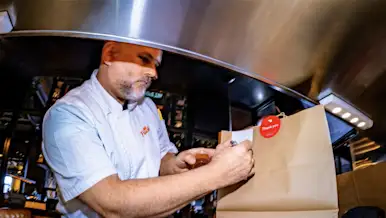 Mx Blog - Understanding the Rise of Food Delivery Services - chef preparing DoorDash bag