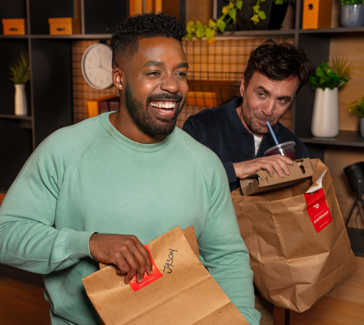 DDfB two men receiving DoorDash bags, man drinking