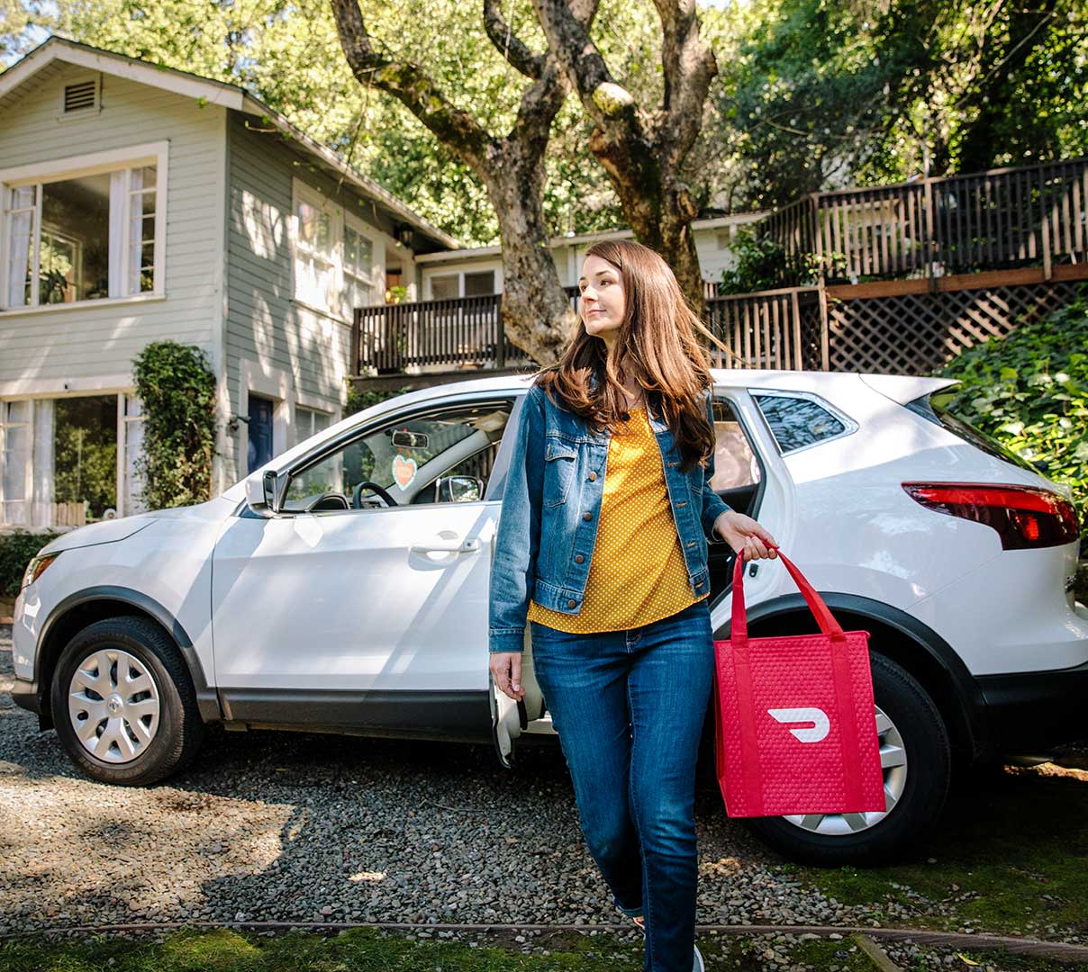 Delivery driver carrying bag, making a delivery.