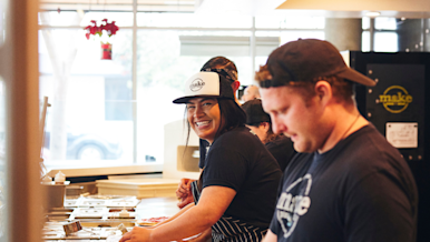 Restaurant service, staff smiling and making pizzas at a restaurant