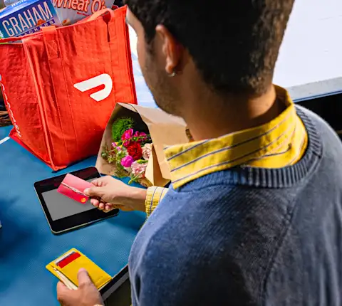 A Dasher paying for a delivery order with their Red Card