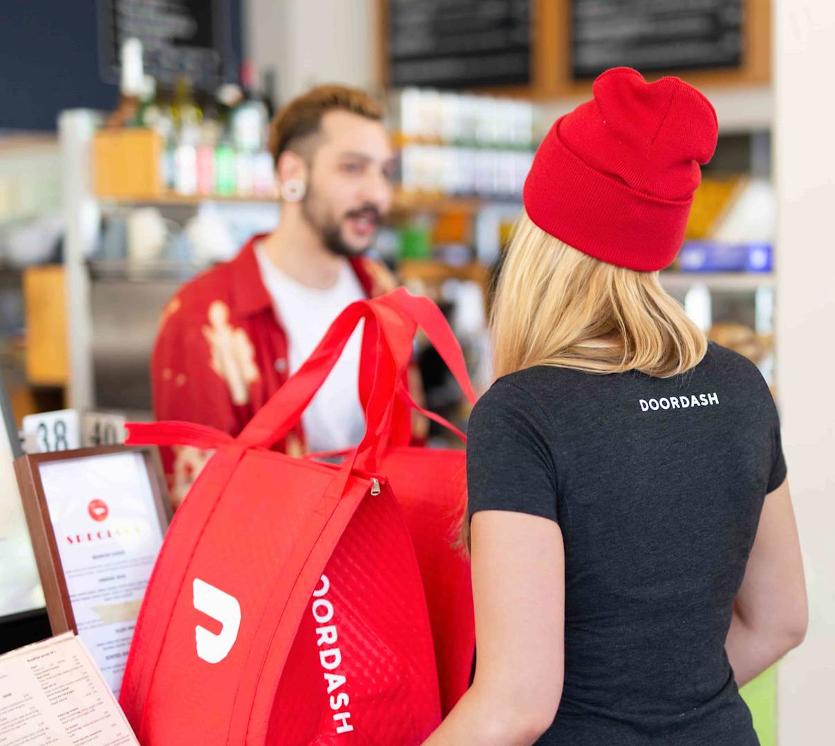 women picking up food order with doordash