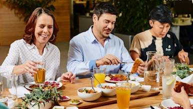 People eating around a table with a meal that appears to be catering