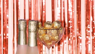 Champagne bottle seated next to chocolate
