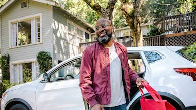 Dx Blog (US/CA/AU/NZ) - Rideshare vs. Food Delivery: What Type of Gig Work Is Right for You? - Dasher smiling holding delivery bag