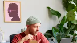 DDfB Man eating noodles in front of computer