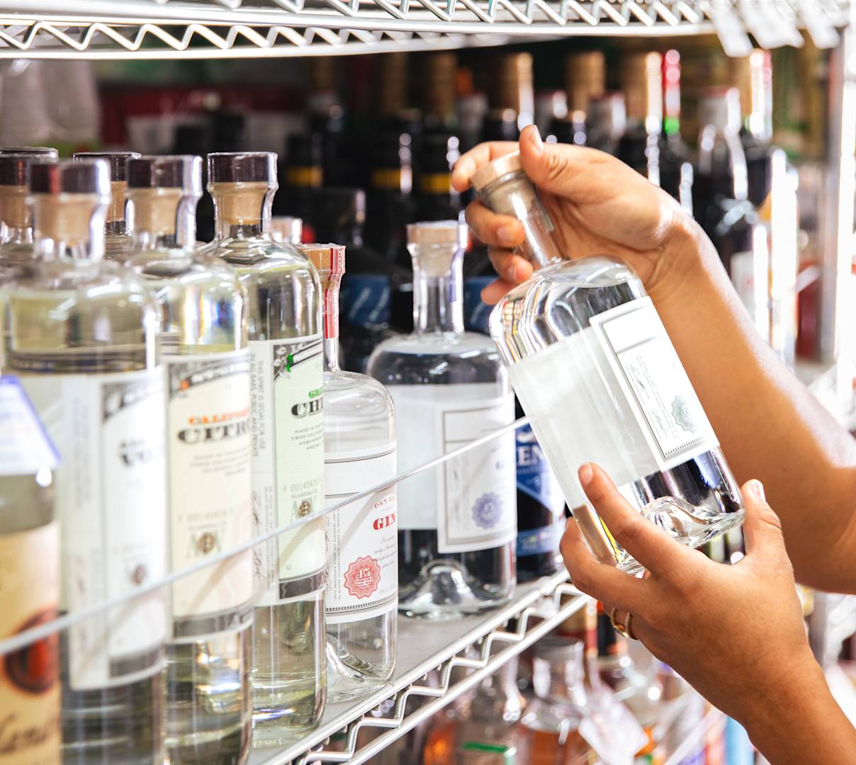 Hands holding bottle in alcohol aisle