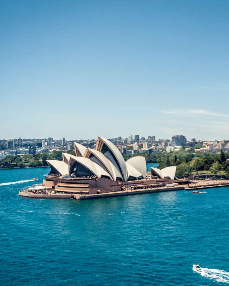 aerial shot over the Sydney Opera House towards the bridge over the bay