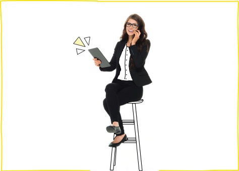 Mujer joven vestida de ejecutiva sentada hablando por teléfono y navegando en su Tablet gracias a una de nuestras tarifas de fibra y móvil para negocios