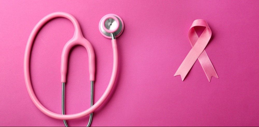 Un estetoscopio al lado de un moño rosa