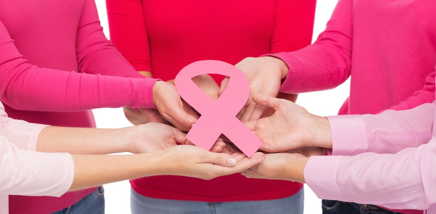 Conjunto de personas cargando un moño rosa