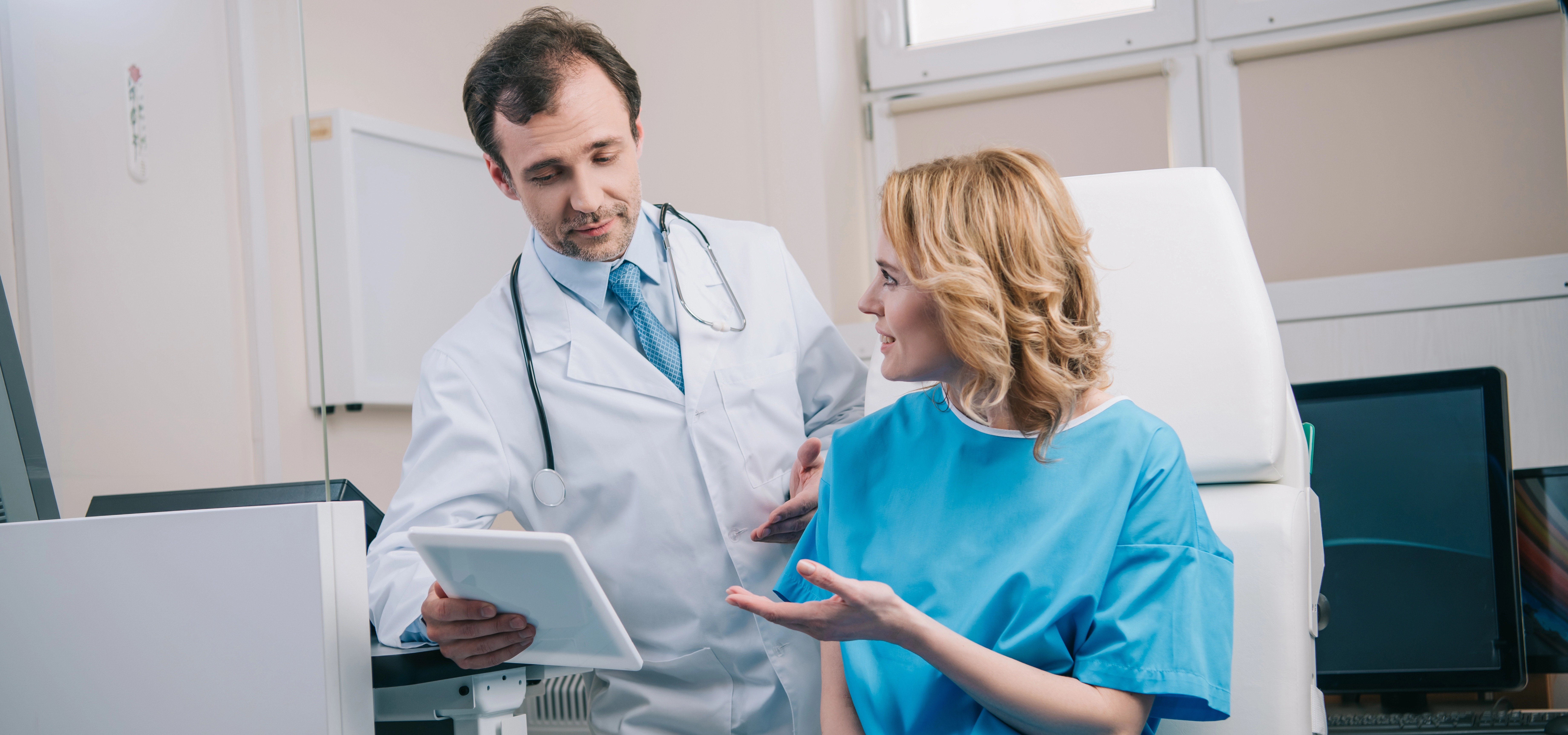 Mujer feliz hablando con el médico sonriente sosteniendo tableta digital