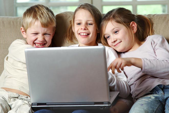 3 kids looking at labtop