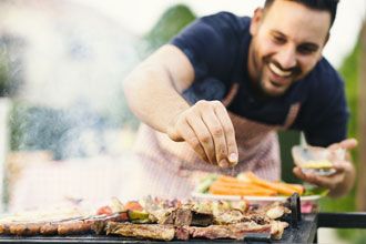 Man standing close to hot grill