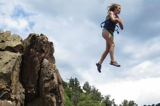 Woman jumping off cliff into water