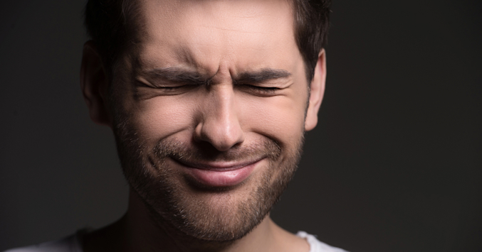 Man wincing in pain.