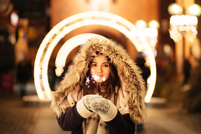 girl holding sparklers near her eyes